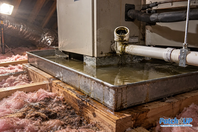 Overflowing drip pan under an attic air handler in a North Dallas attic
